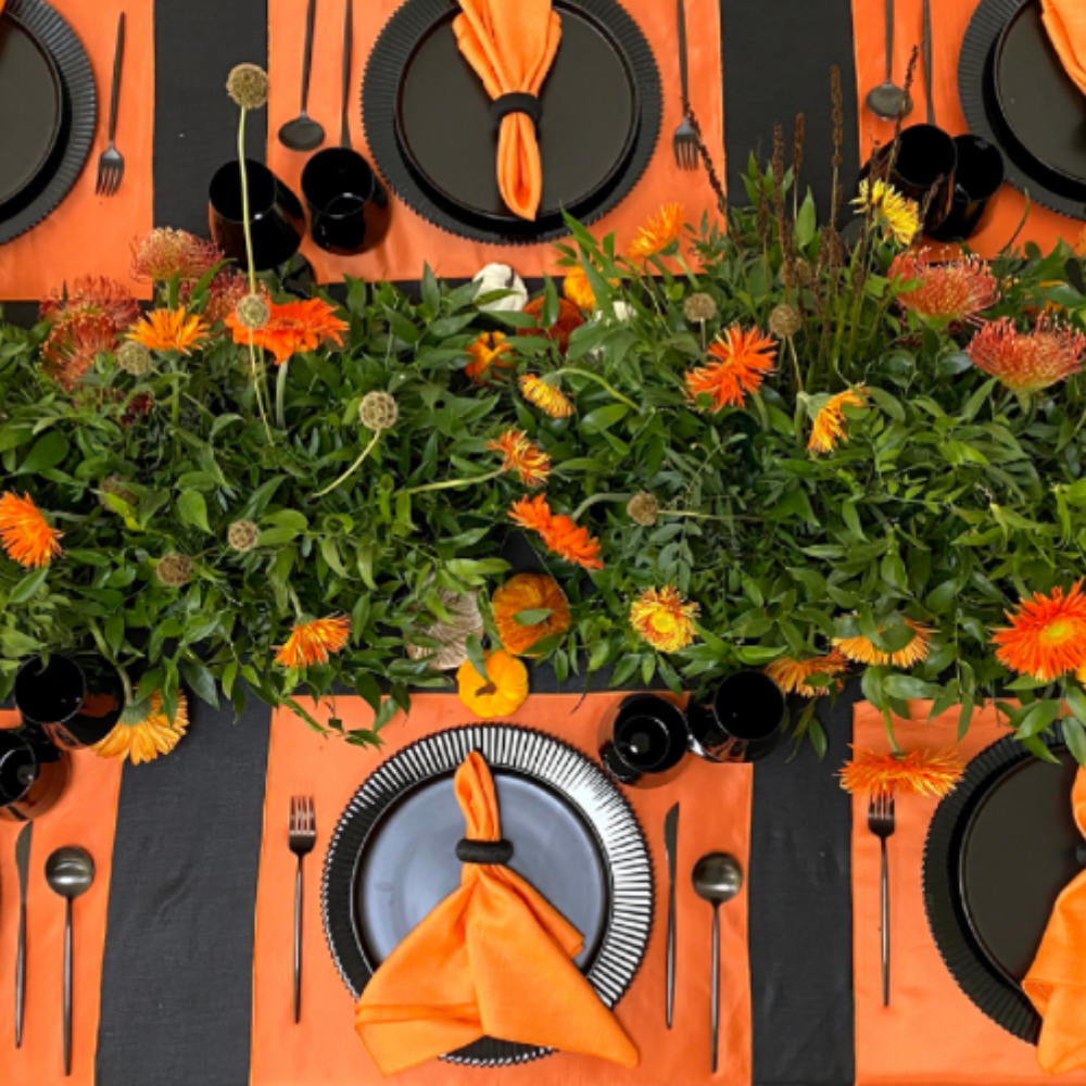 Pumpkins & Petals- Dining Setup for 8, featuring charger plates, gold cutlery, glassware, napkins, acrylic chairs, and a greenery centerpiece with pumpkins. Perfect for festive occasions.