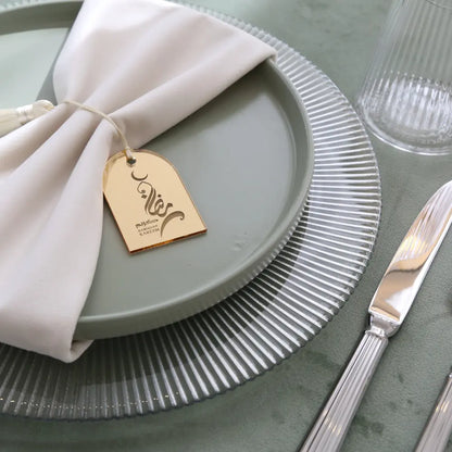 CHARGER PLATE - LINED featured as an elegant base for a Ramadan-themed setting, showcasing its premium design with a white napkin and gold-tone tag.