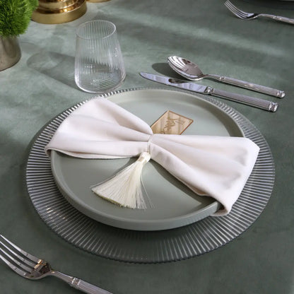CHARGER PLATE - LINED enhances this elegant table setting with polished silverware, a bow-tied napkin, and a fluted tumbler, perfect for stylish dining events.