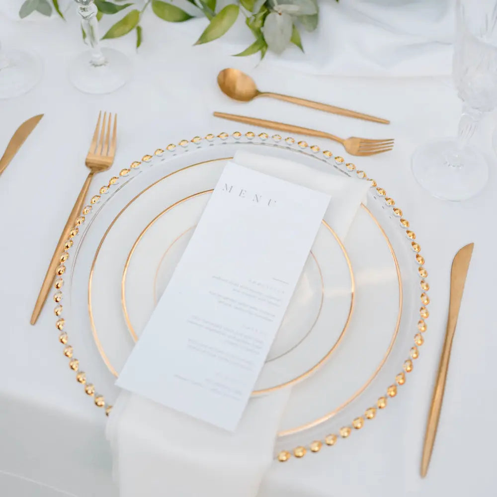 CHARGER PLATE - BEADED: A luxurious glass charger plate with a gold beaded rim, elevating formal dining settings.