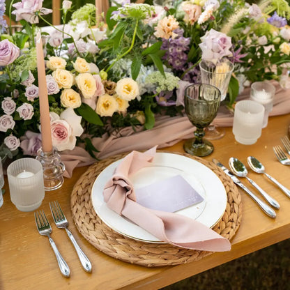 CANE PLACEMAT on an elegant table setting with china plate, knotted napkin, silver flatware, glassware, candles, and floral arrangement for a romantic occasion.