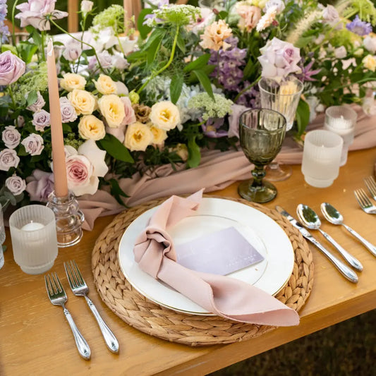 CANE PLACEMAT on an elegant table setting with china plate, knotted napkin, silver flatware, glassware, candles, and floral arrangement for a romantic occasion.