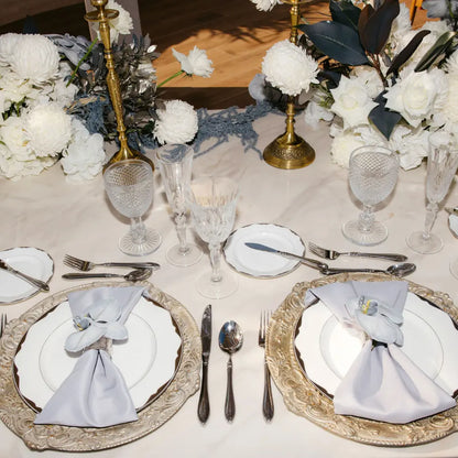 CHARGER PLATE - FLORENTINE ANTIQUE WOOD at an elegant table setting with ornate plates, floral napkin rings, crystal glasses, silver flatware, and a floral centerpiece.