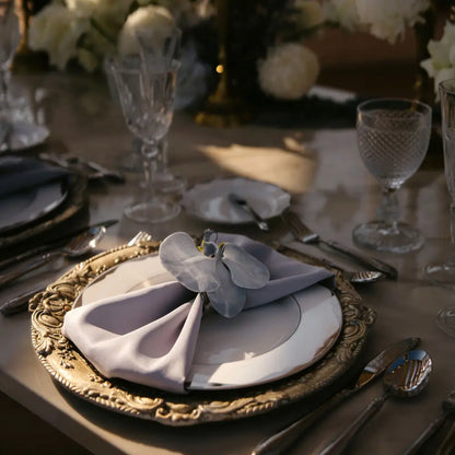 CHARGER PLATE - FLORENTINE ANTIQUE WOOD featured in an elegant table setting with silver utensils, crystal glasses, and a folded napkin with an orchid.