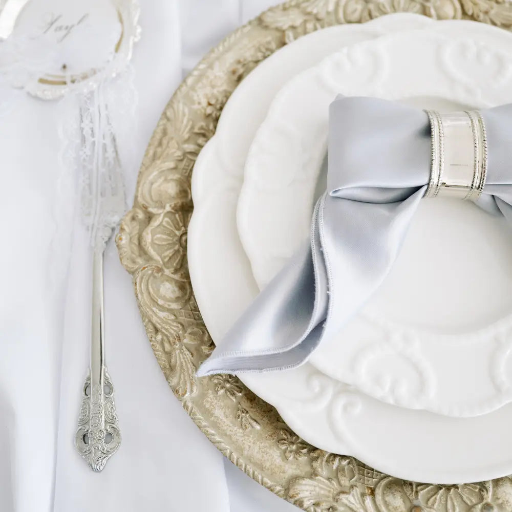 CUTLERY VINTAGE SILVER (SET OF 4 PIECE) elegantly displayed beside embossed plates and a napkin, ideal for sophisticated events.