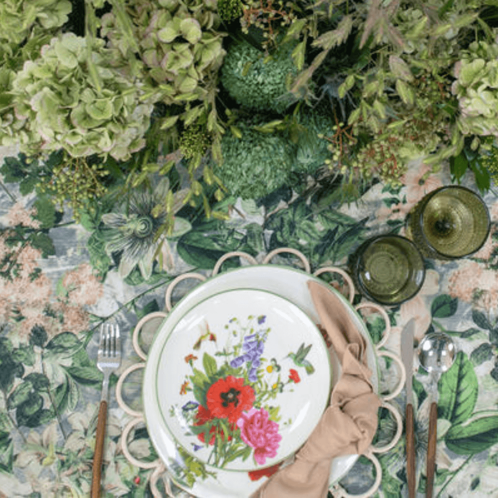 Garden Bliss- Dining Setup: A floral-designed plate with napkin and cutlery on a table, part of an elegant tableware set for eight guests.