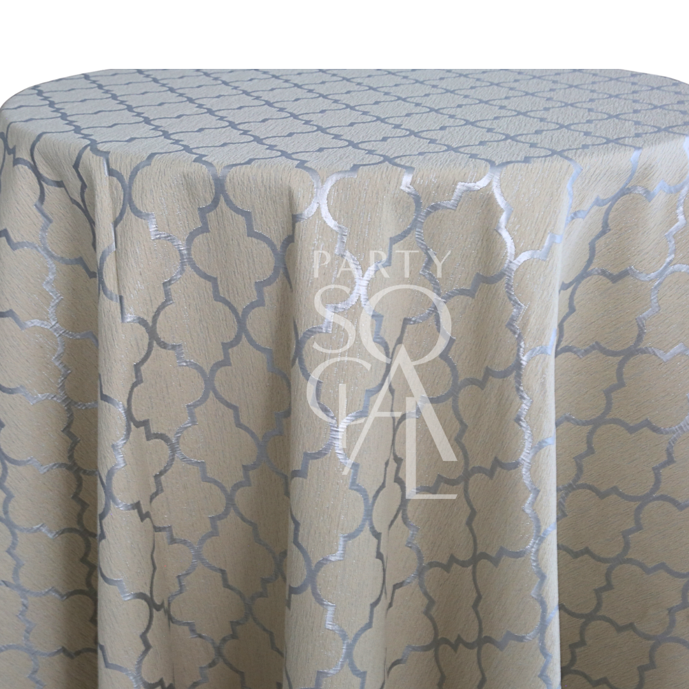 IVORY AND SILVER TRELLIS TABLE CLOTH featuring a light-beige fabric with a silver quatrefoil pattern, ideal for enhancing elegant event settings.