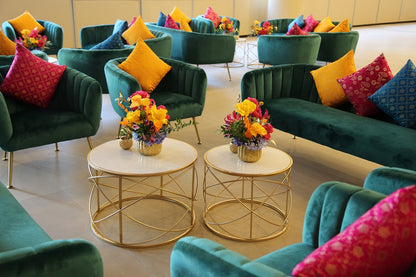 ROYAL GREEN VELVET 3-SEATER with gold-finish legs, surrounded by elegant decor, ideal for lounge seating at events.