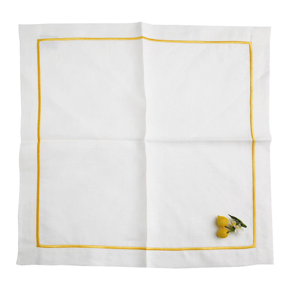 A white linen dinner napkin with a yellow border and two lemons.