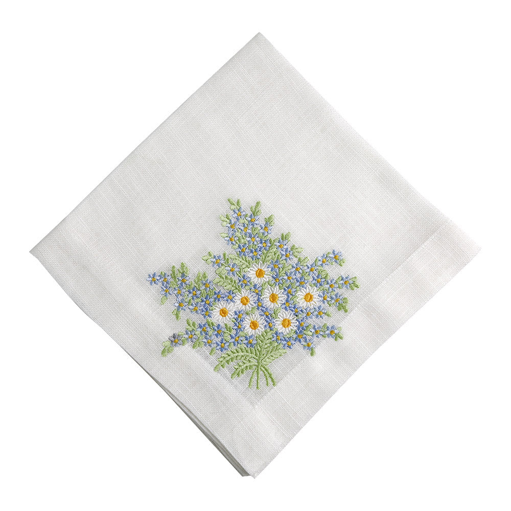A white linen dinner napkin with delicate flower embroidery. Perfect for adding an elegant touch to your special table setups.