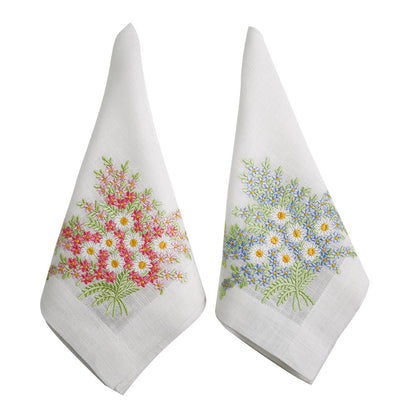 A pair of white linen dinner napkins with elegant floral embroidery. Perfect for special table setups.