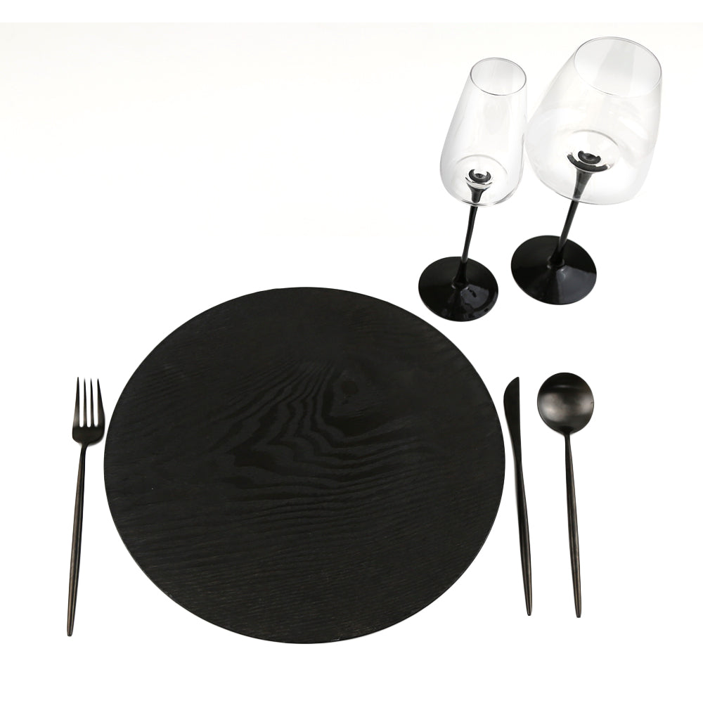 Simple Plastic Wooden-Like Charger Plate on a black placemat with two wine glasses and a spoon, ideal for elegant table settings.