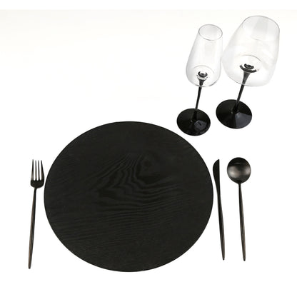 Simple Plastic Wooden-Like Charger Plate on a black placemat with two wine glasses and a spoon, ideal for elegant table settings.