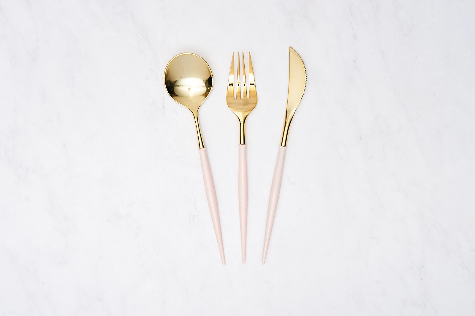 Bella Plastic Cutlery in Gold and Pink featuring a spoon, fork, and knife, showcasing a sleek modern design perfect for elevating any table setting or event.