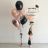 Blush Rose Bliss Balloon Bouquet featuring a black and rose-gold theme with confetti-filled balloons and a personalized congratulatory message, perfect for elegant graduation celebrations.