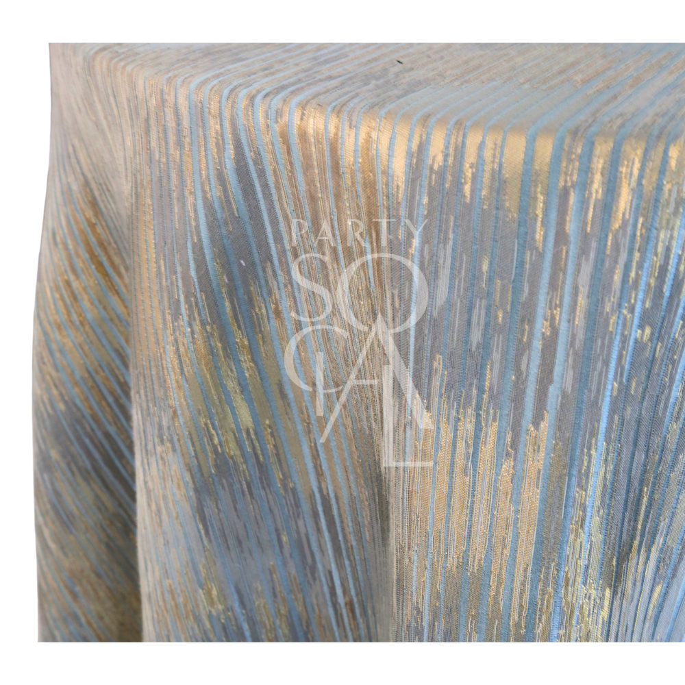 CELESTIAL HORIZON TABLECLOTH with textured, iridescent stripes in soft blues and metallic golds, creating a twilight sky effect, ideal for elegant events.