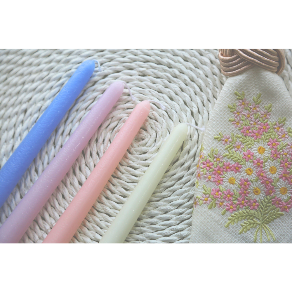 The Tapered Flame Smokeless Candles arranged with an embroidered floral pouch, showcasing artisan craftsmanship, perfect for elevating any event&