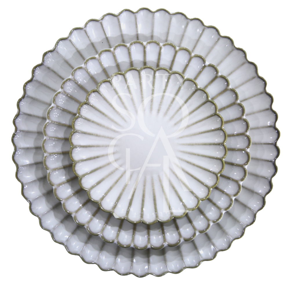 SCALLOPED LIKE PLATES: Three elegantly stacked white ceramic plates with scalloped, fluted rims, embodying a shell-like design for sophisticated dining occasions.