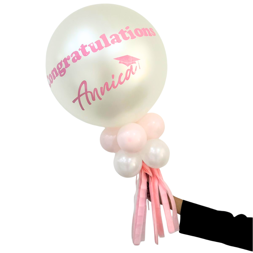 Personalized Balloon Wand with Congratulations Annica in pink, featuring a large pearlescent balloon, smaller pink and white balloons, and pink streamers, perfect for memorable celebrations.