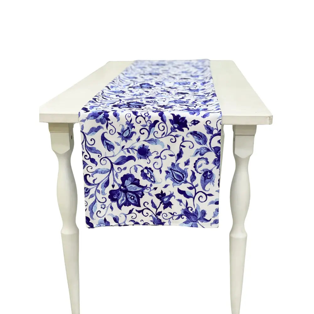 Summer Florals Polyester Linen Runner on a white wooden table, featuring a blue floral pattern, perfect for enhancing special event tablescapes from Party Social.