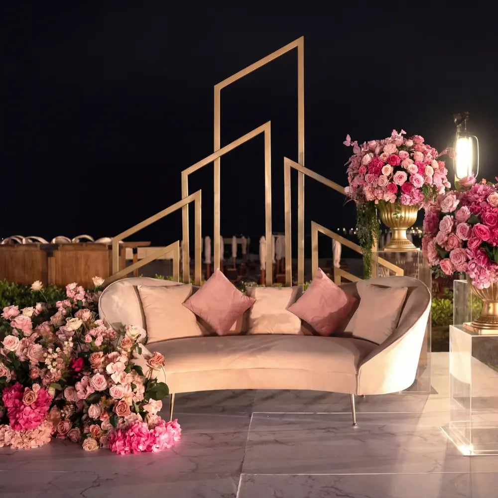 Asymmetric Abstract Backdrop in gold, featured behind a blush sofa with floral arrangements, ideal for weddings or events, enhancing elegant settings.