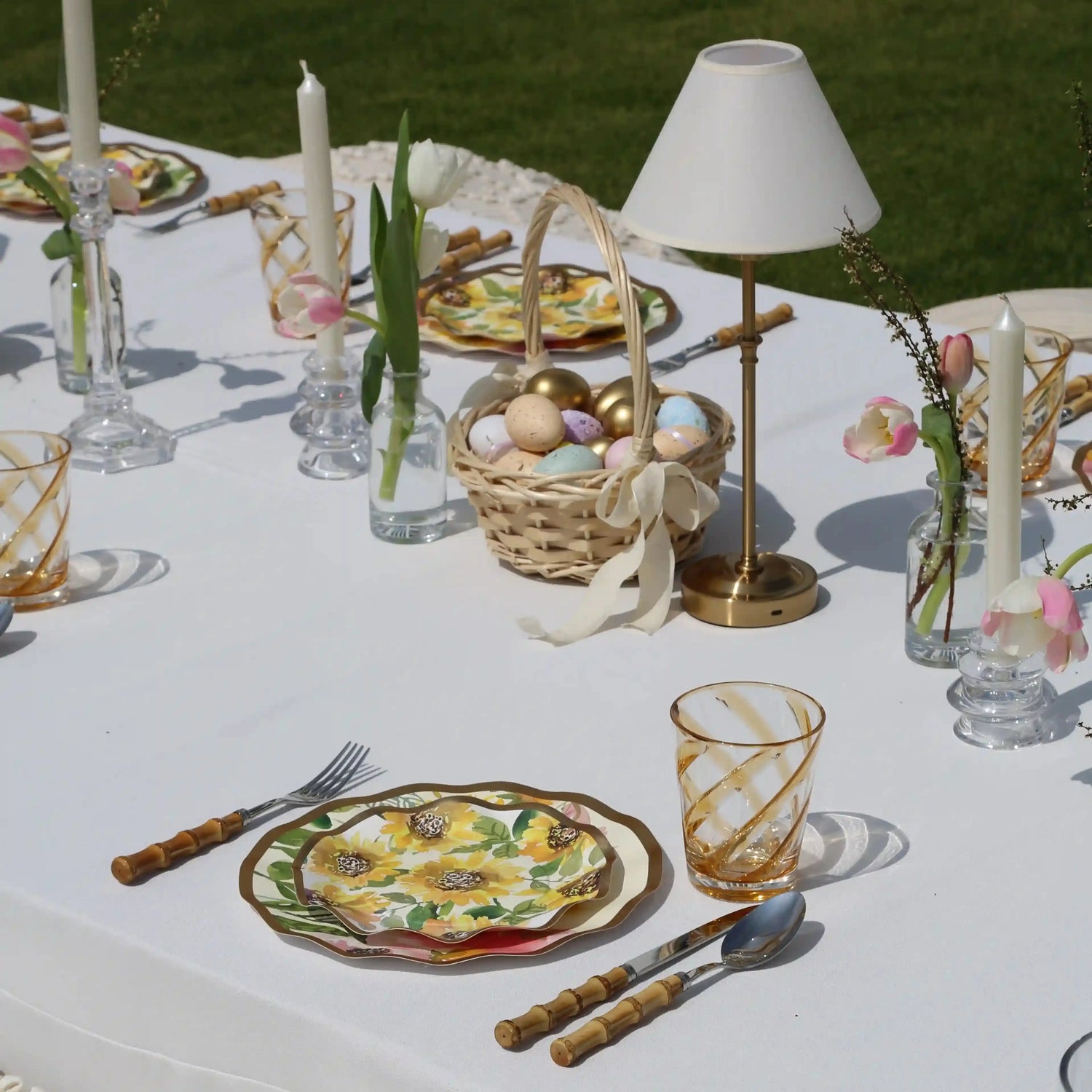 Amber Spiral Colored Acrylic Glass - Set of 4: Amber-swirled acrylic tumblers set on a spring-themed table with sunflower plates and pink-white tulip vases. Ideal for stylish outdoor dining.