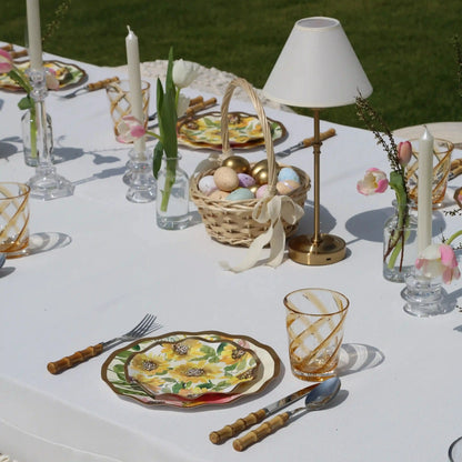 Amber Spiral Colored Acrylic Glass - Set of 4: Amber-swirled acrylic tumblers set on a spring-themed table with sunflower plates and pink-white tulip vases. Ideal for stylish outdoor dining.