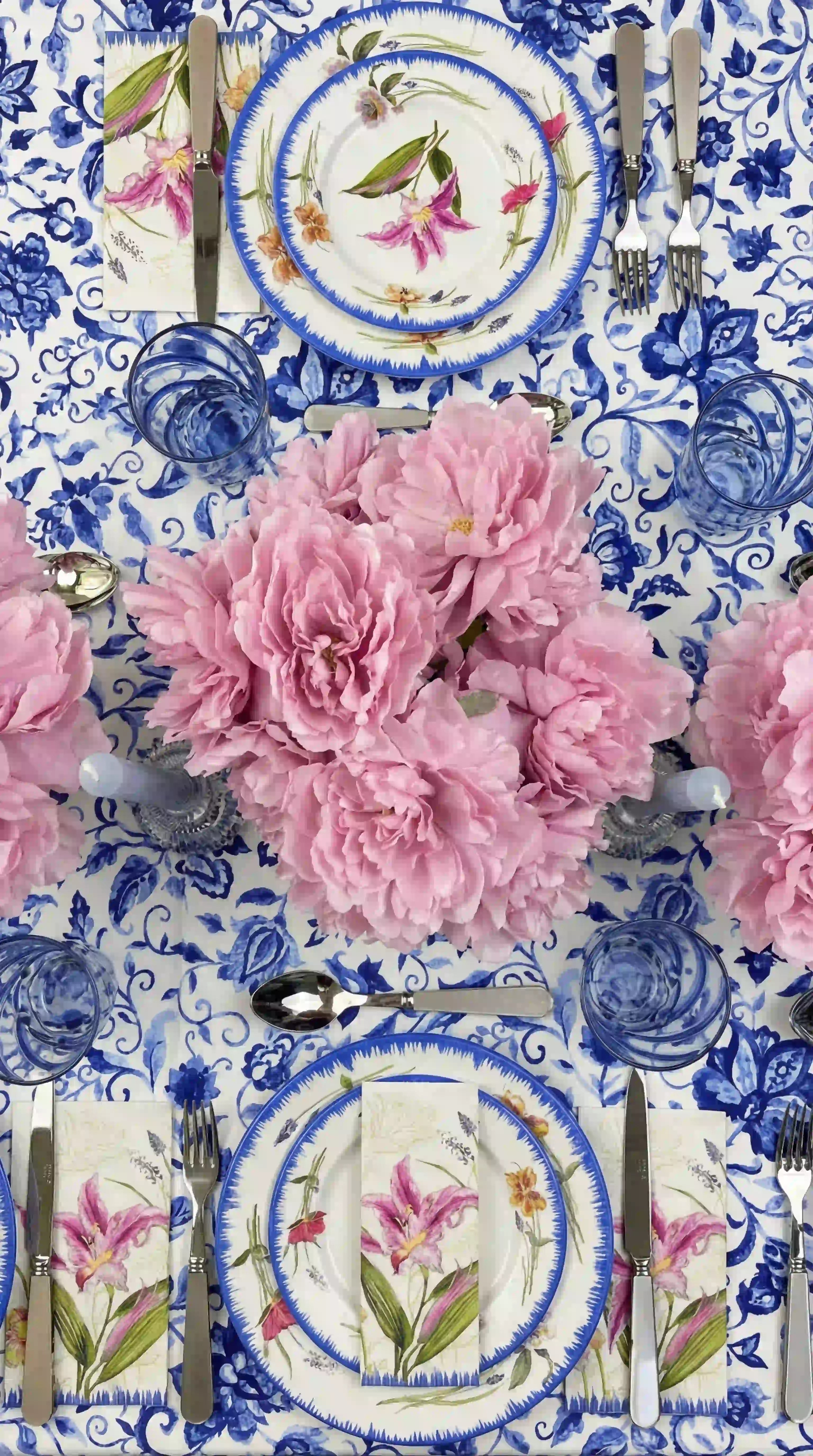Azure Garden Floral Tablecloth with vibrant floral pattern, set beneath elegant china, peonies, and silver candleholders in a sophisticated spring table setting.