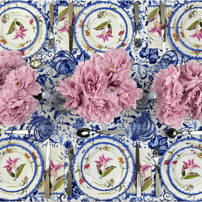 Azure Garden Floral Tablecloth elegantly set with floral plates, matching napkins, and blue glassware, accented by lush pink bouquets, enhancing any event setting.