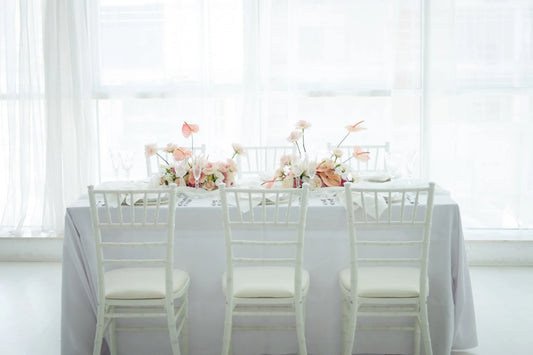 TABLE 6' RECTANGULAR BANQUET set with white chairs and floral centerpiece, ideal for events and functions, featured by Party Social.