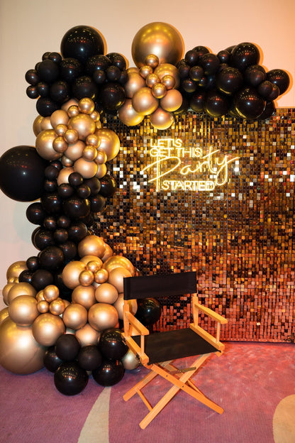 Sequin Wall backdrop featuring a chair and balloon arrangement, ideal for enhancing events like weddings and parties, available in gold and silver.