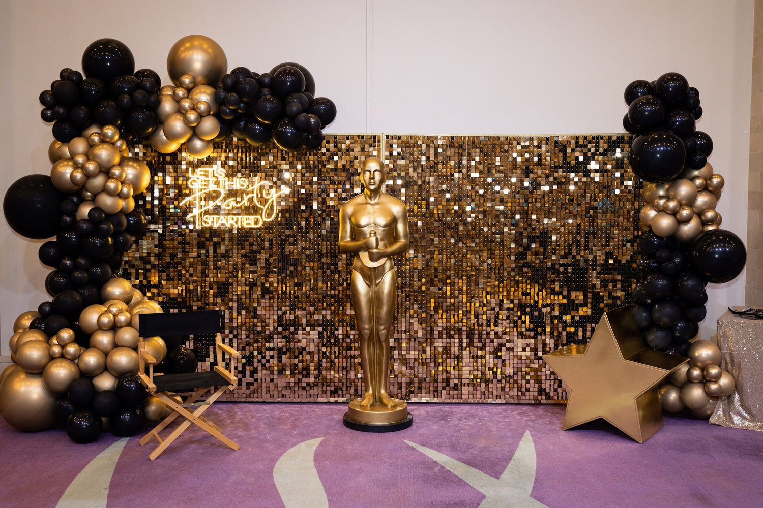 Sequin Wall backdrop with gold statue and balloon decor, ideal for events. Available in gold and silver, props not included.