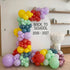 A colorful balloon arch backdrop with the text &