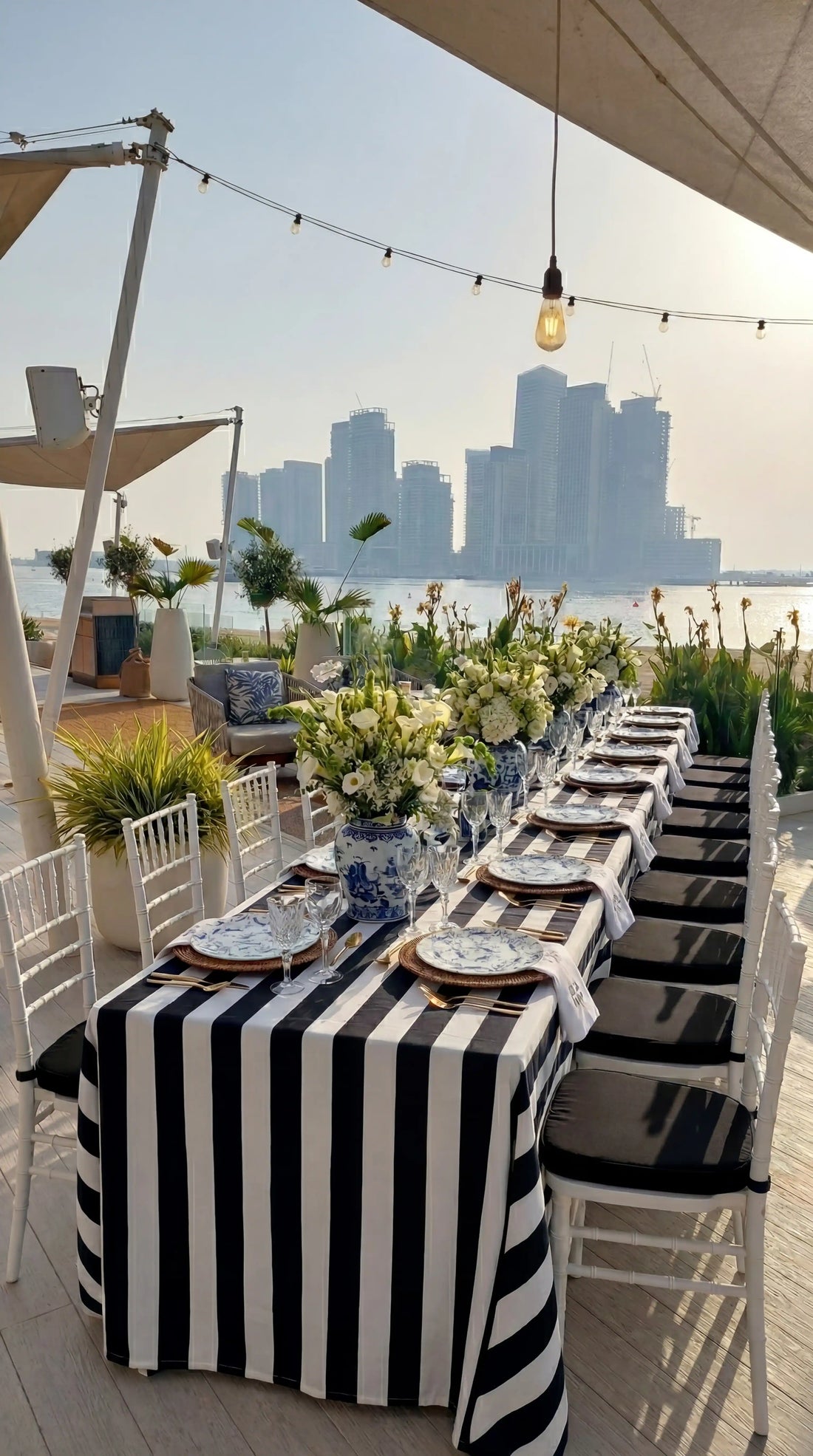 Monochrome Linen Tablecloth on waterfront dining setup with striped design, paired with elegant tableware and floral decor, perfect for sophisticated events.