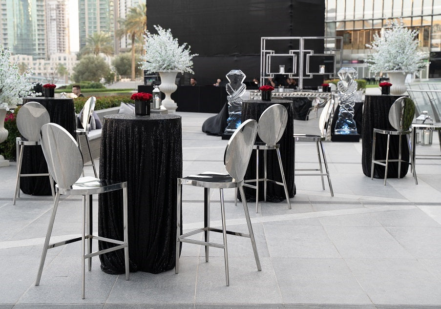 Round Table Cocktail surrounded by chairs and vases, showcasing its versatility for events by Party Social.