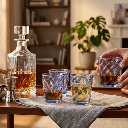 Crystal whiskey decanter and glasses on a wooden table in a cozy living room