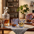 Crystal whiskey decanter and glasses on a wooden table in a cozy living room