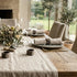 Dining table set with plates, glasses, and a centerpiece in a cozy room.