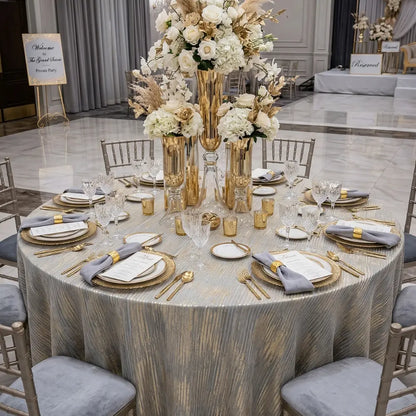 CELESTIAL HORIZON ROUND TABLECLOTH adorns an elegant round table set for a formal event, with gold accents, crystal glassware, and floral centerpieces.