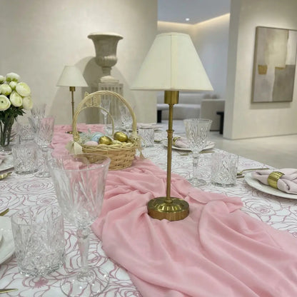 Chiffon Table Runner elegantly drapes across a dining table with gold accents, crystal glassware, and decorative elements, perfect for special occasions by Party Social.
