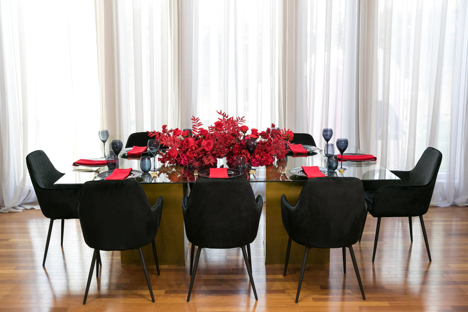 Black &amp; Gold Collection: Elegant table setup with black chairs and red floral centerpiece, perfect for an 8-guest party experience.