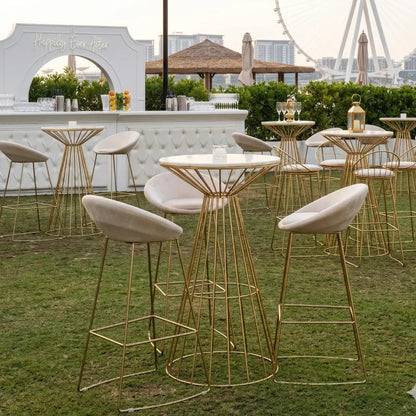 Cream and Gold Base Bar Stools, featured in an elegant wedding setup, showcasing modern velvet seats with gold legs, perfectly complementing the upscale event ambiance.