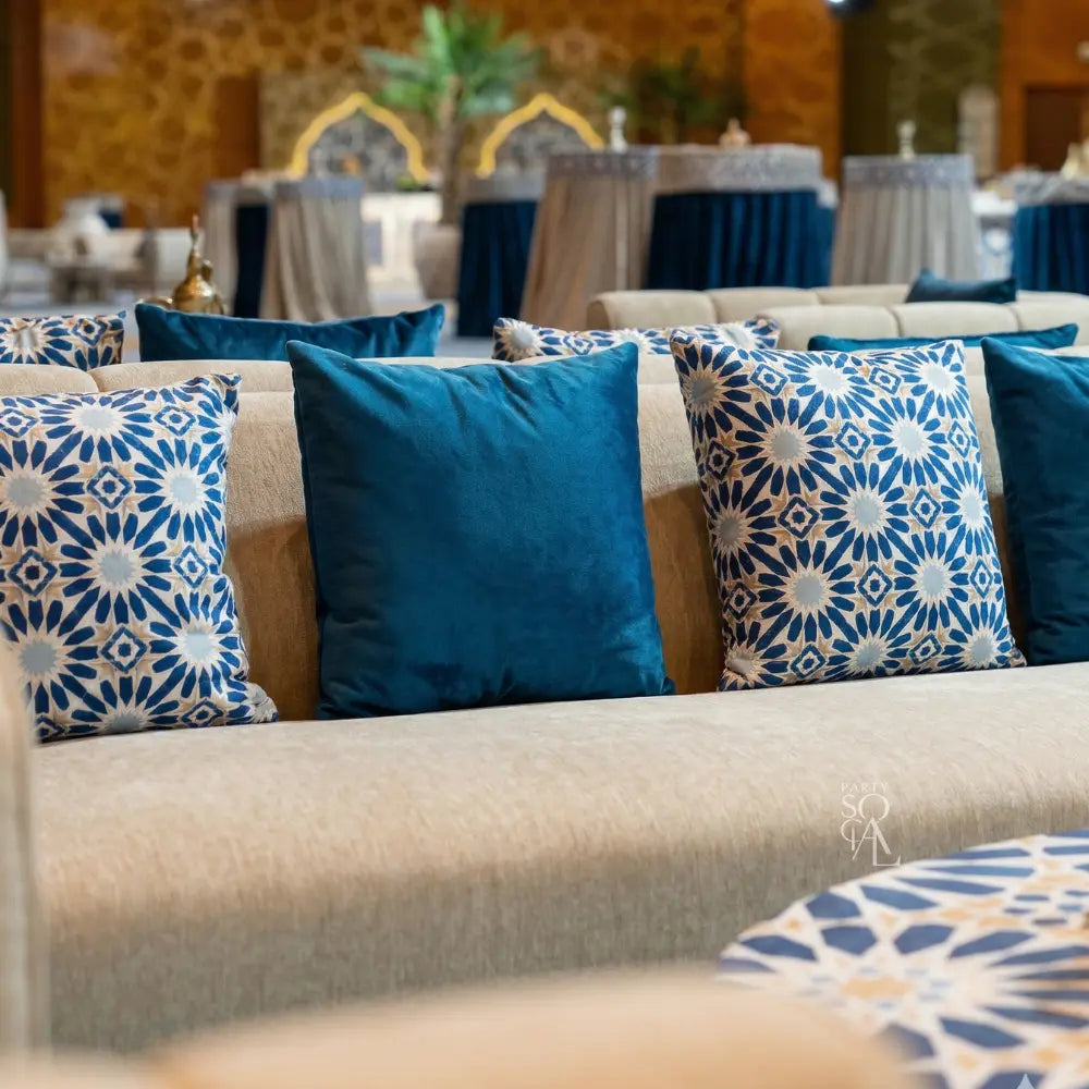 CUSHION ARABESQUE PRINT on a light sofa, featuring deep-blue velvet and blue-and-white geometric starburst patterns, ideal for stylish event lounges.