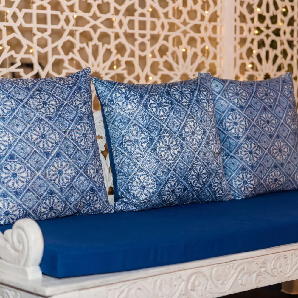 CUSHION BLUE AND WHITE MOROCCAN PRINT on a carved bench, featuring a geometric pattern with a soft filler, ideal for seating arrangements at events.