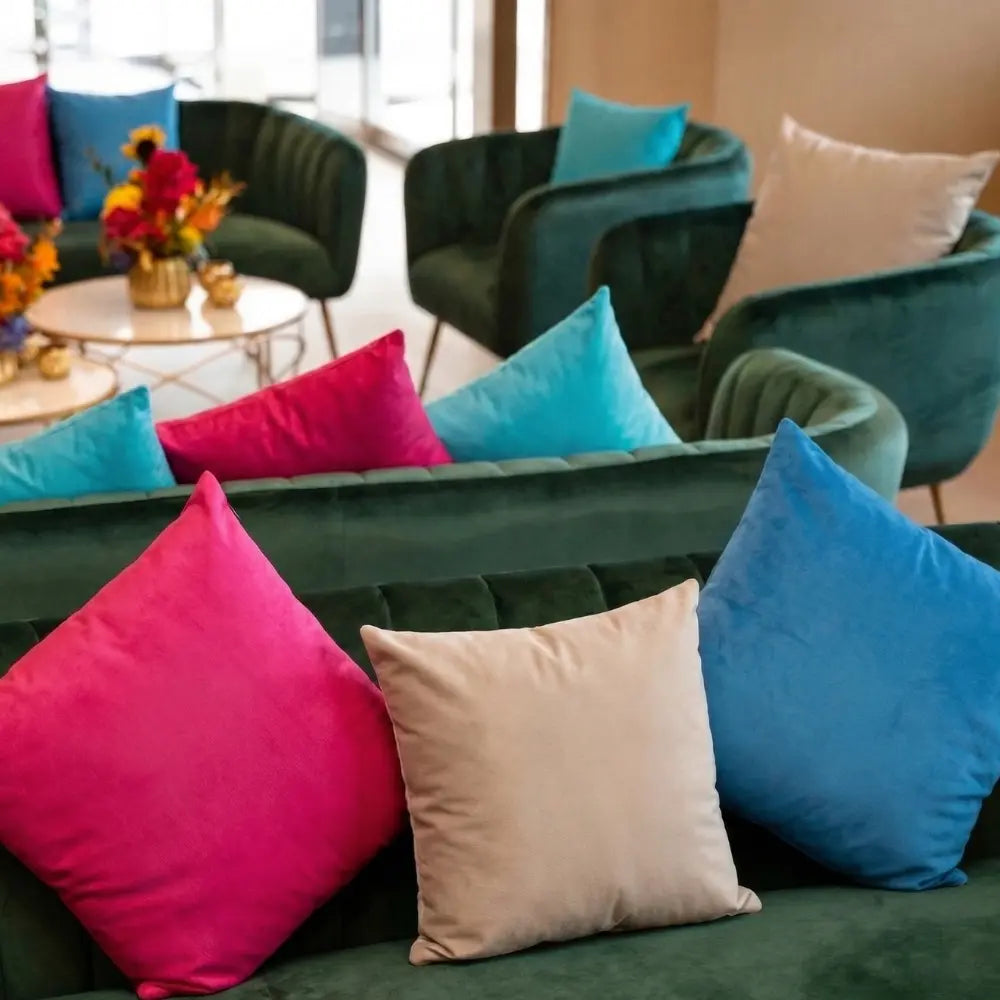 CUSHION COVER LINEN BLEND adorns a velvet sofa, enhancing a modern lounge with vibrant, ready-to-use, soft linen covers, ideal for event seating.