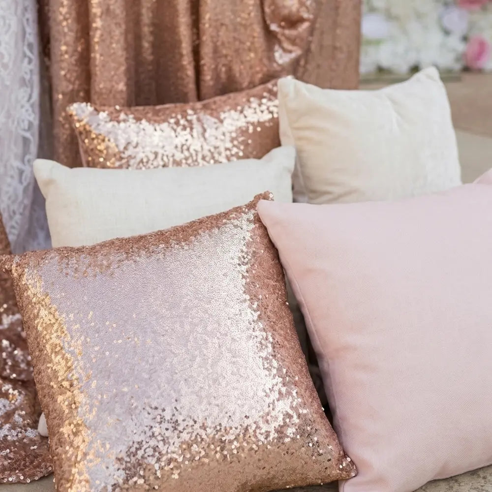 CUSHION COVER SEQUIN displayed with blush and neutral pillows; features premium sequin fabric, perfect for enhancing any event decor. Includes filler, ready for immediate use.