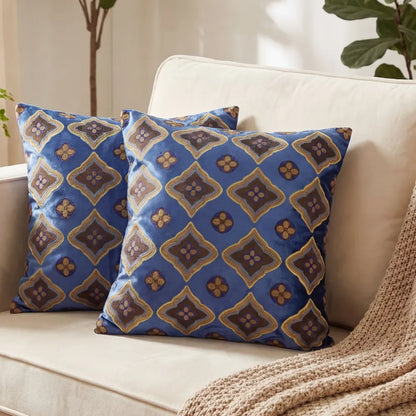 CUSHION PATTERNED BLUE &amp; EARTH TONES on a light sofa with two decorative pillows, featuring a rich blue, brown, and gold motif, perfect for cozy event settings.