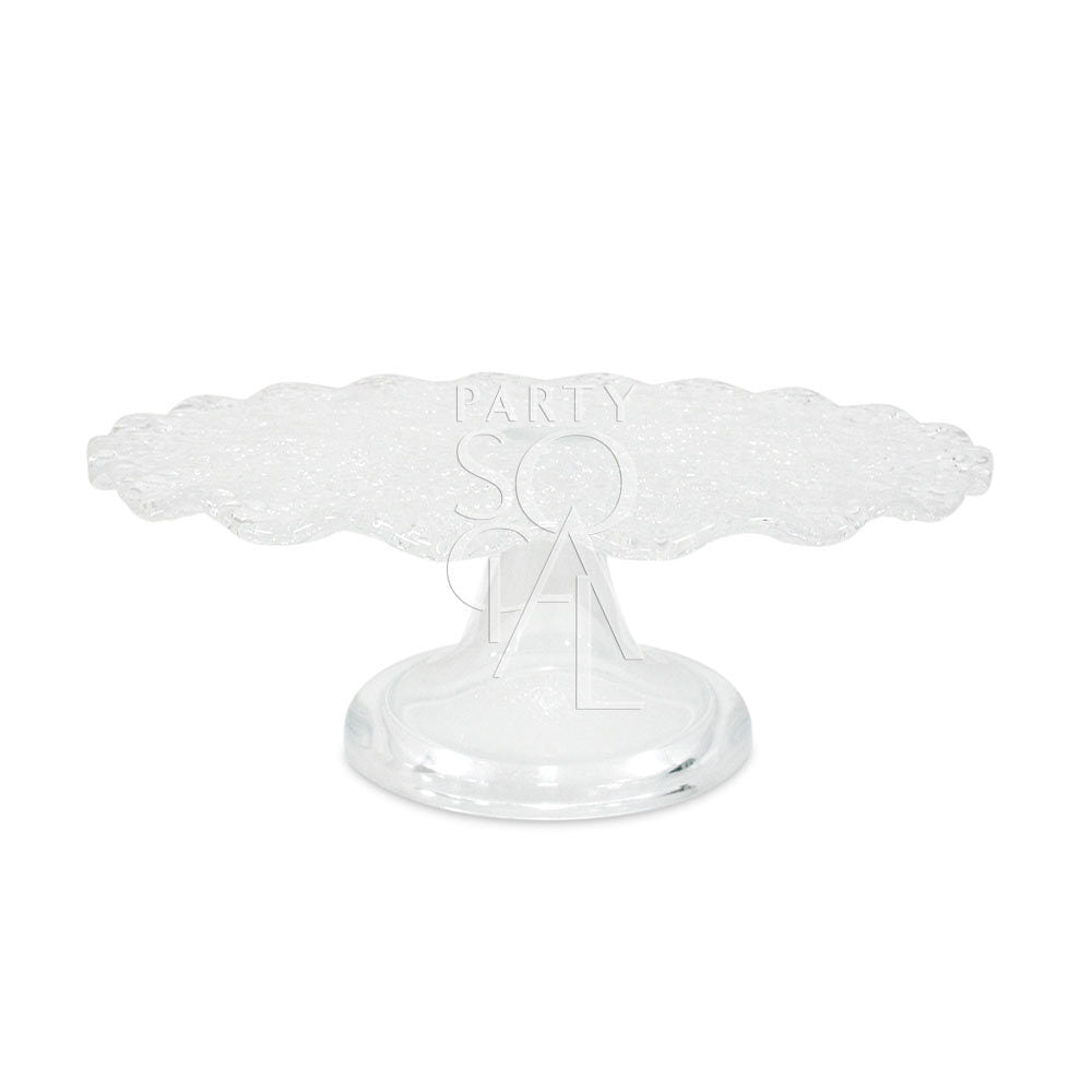 Clear cracked glass cake stand with a scalloped edge, ideal for showcasing cakes or as a centerpiece. Available in two sizes from Party Social.