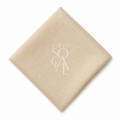 A square caramel cream linen napkin displayed diagonally on a clean white background.
