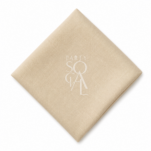 A square caramel cream linen napkin displayed diagonally on a clean white background.
